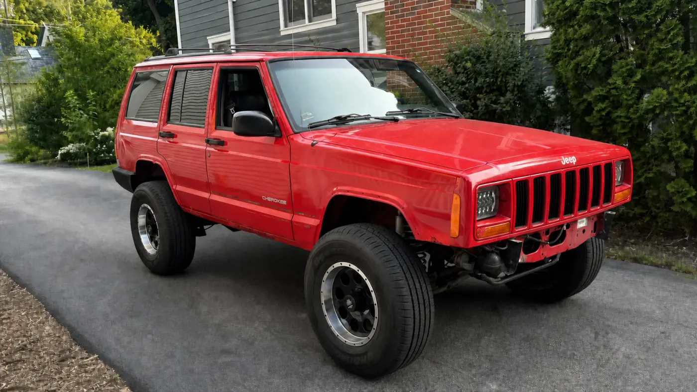 Restored red 2001 Jeep Cherokee parked in a driveway