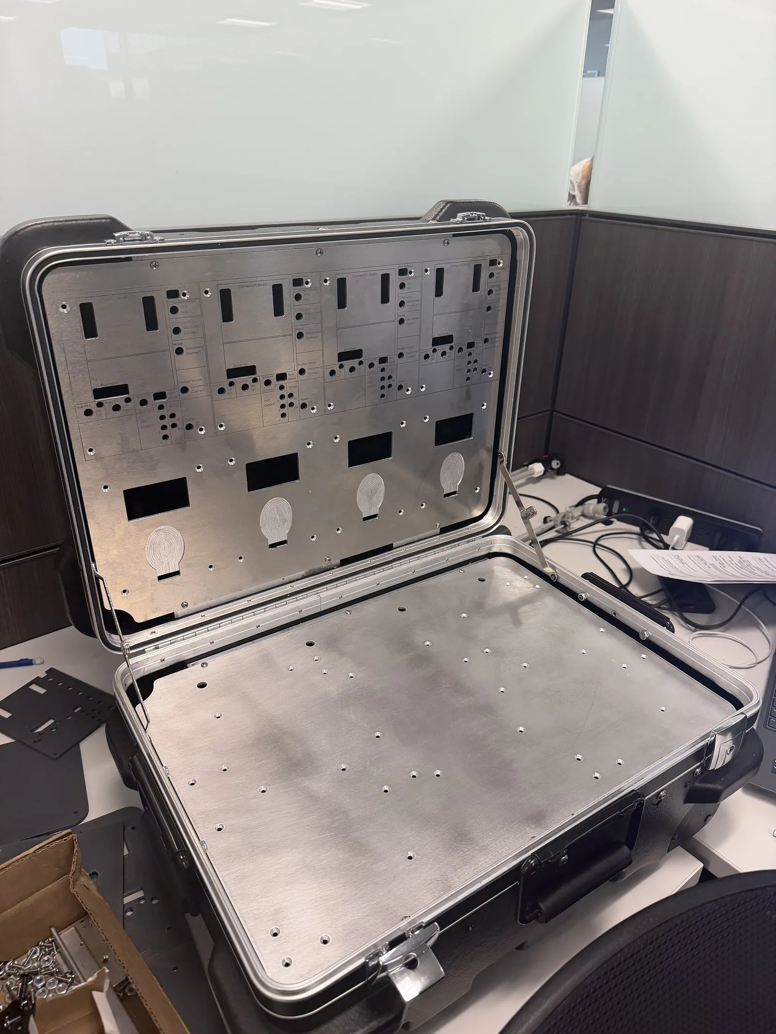 Open hard-shell case with perforated aluminum mounting panels in the lid and base